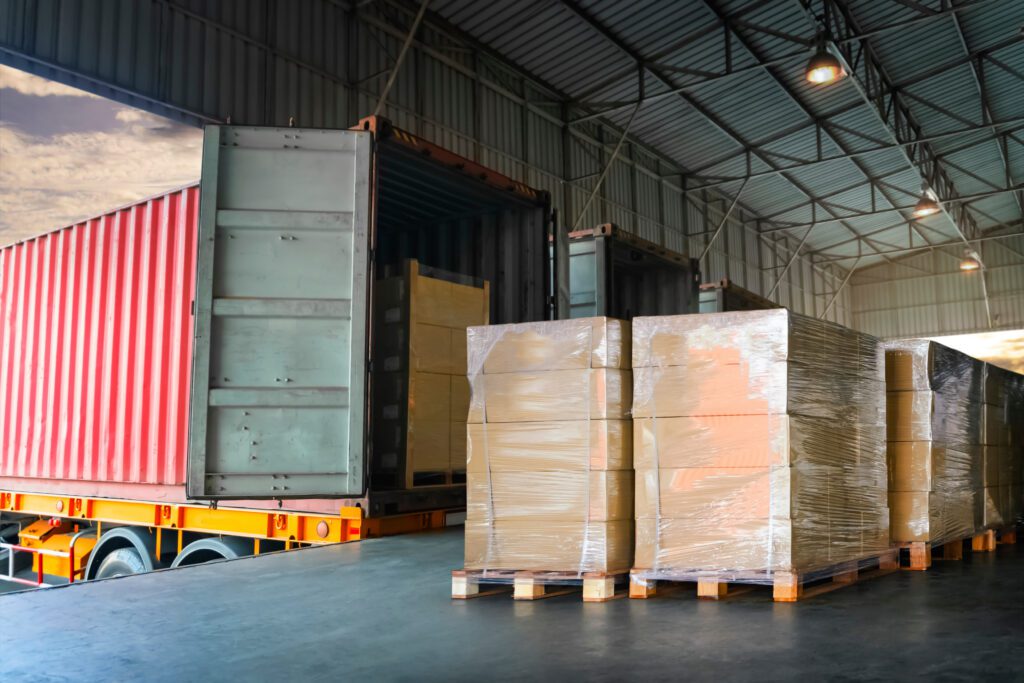 Package Boxes Wrapped Plastic Stacked on Pallets Load into Cargo Container. Trucks Loading Dock Warehouse. Shipping Supply Chain Shipment. Freight Truck Logistics Cargo Transport